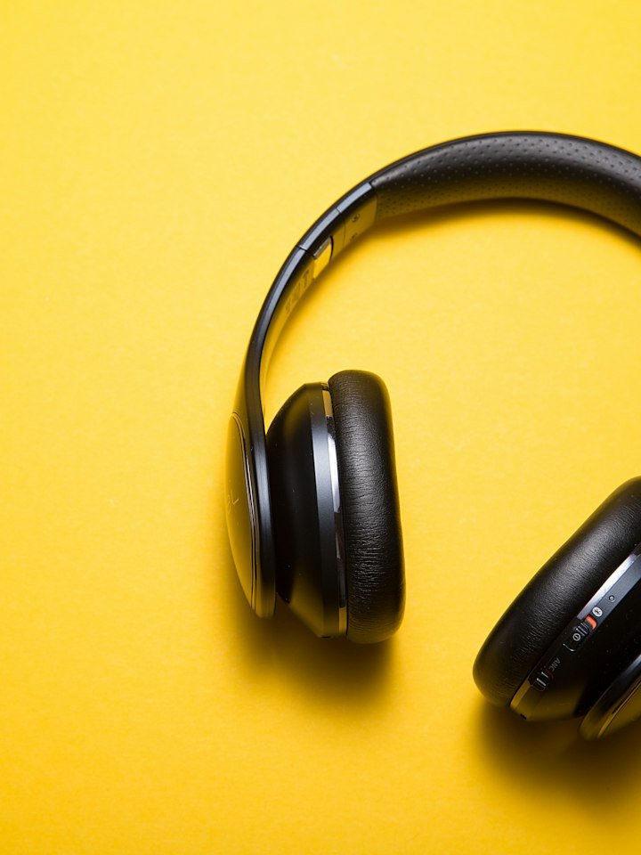Black over-ear headphones on a yellow background
